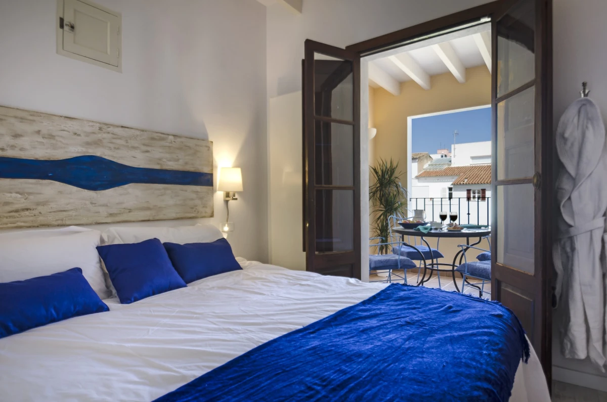 A bedroom in a two bedroom apartment, with doors onto the terrace