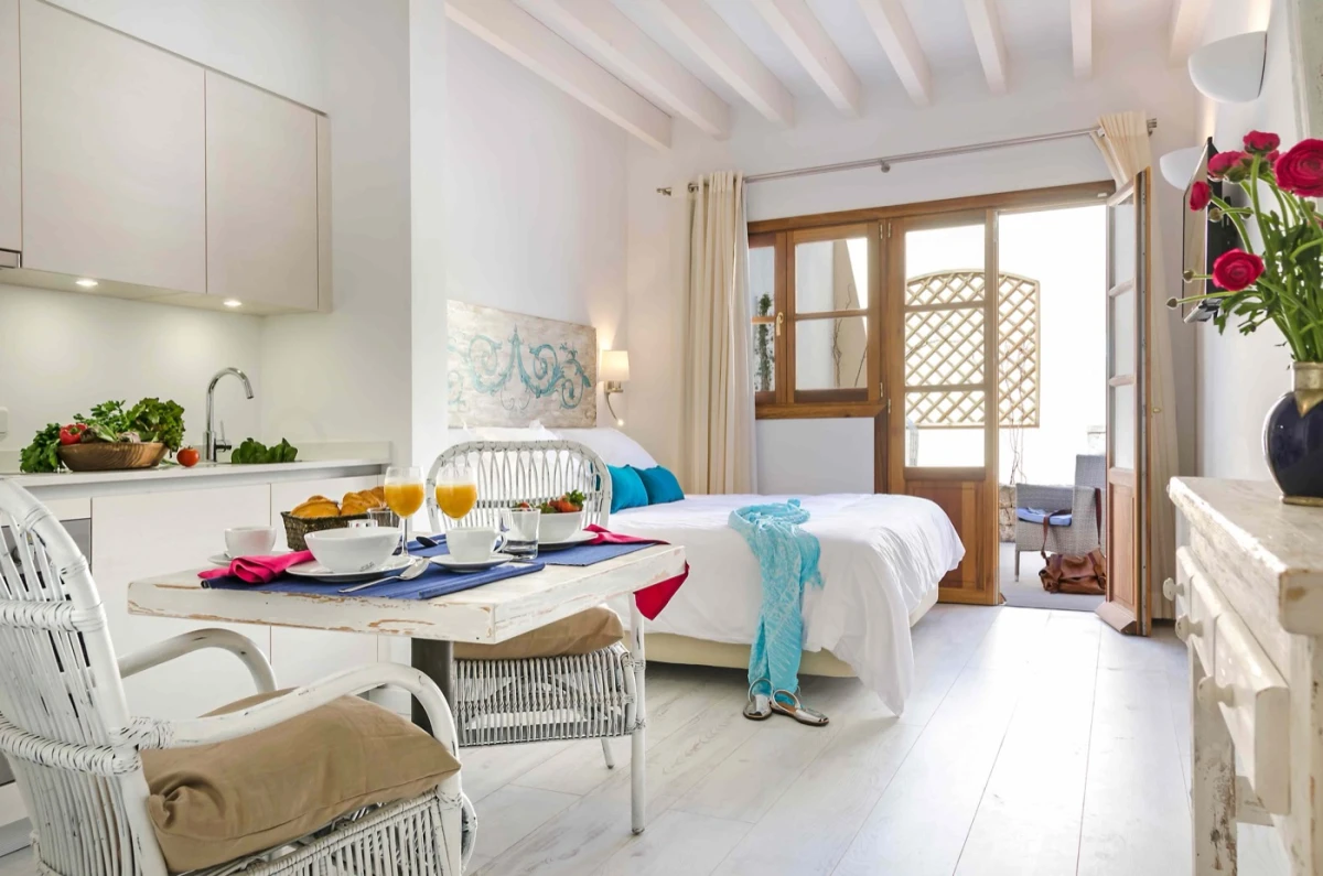 Ground floor studio with kitchen, seating and doors to the patio