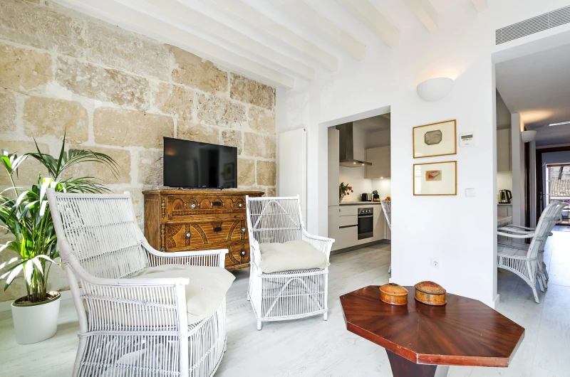 The living area of a two bedroom apartment with wicker chairs